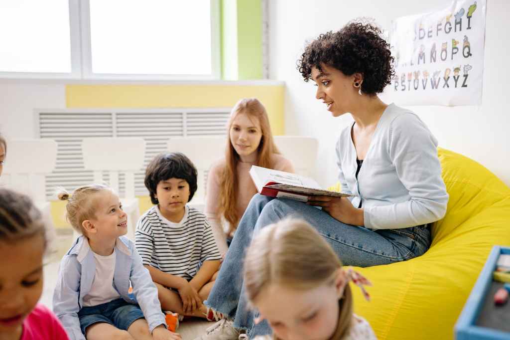 educatrice legge libro a bambini in scuola materna